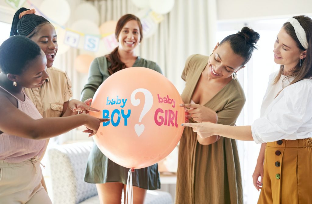 Shot of a group of women about to pop a balloon for a gender reveal during a baby shower