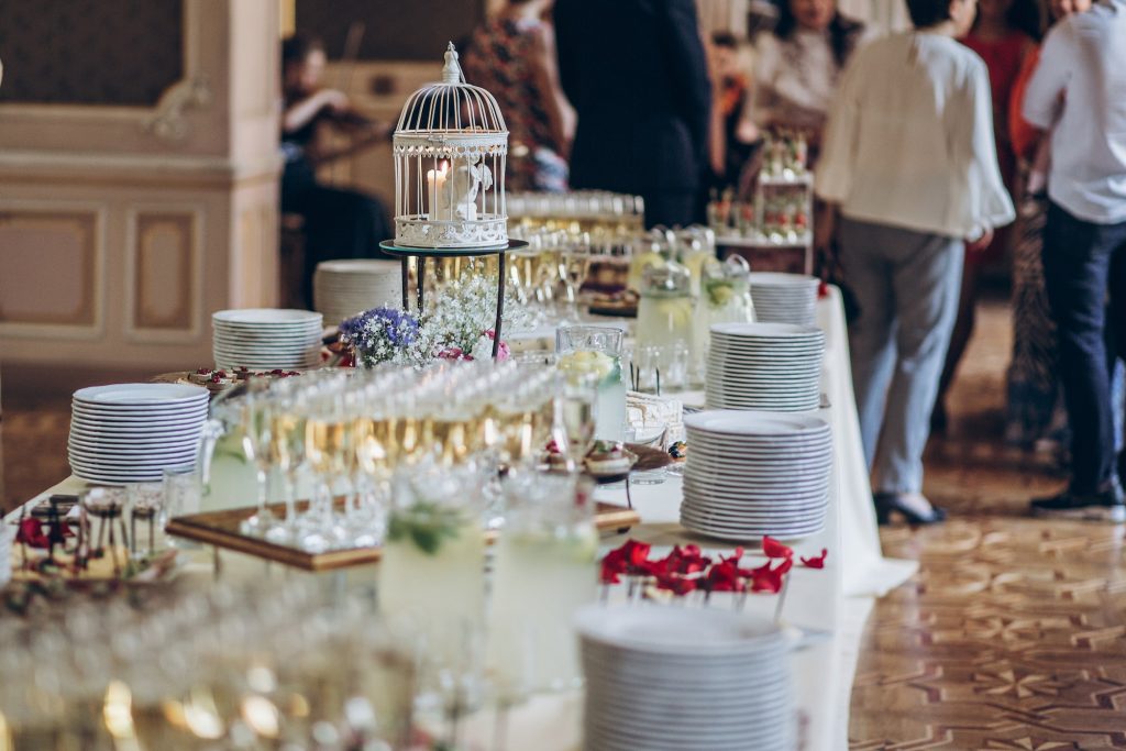 Stylish champagne glasses and food appetizers on table at wedding reception
