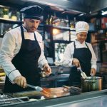 Two professional cooks working in the kitchen at restaurant.