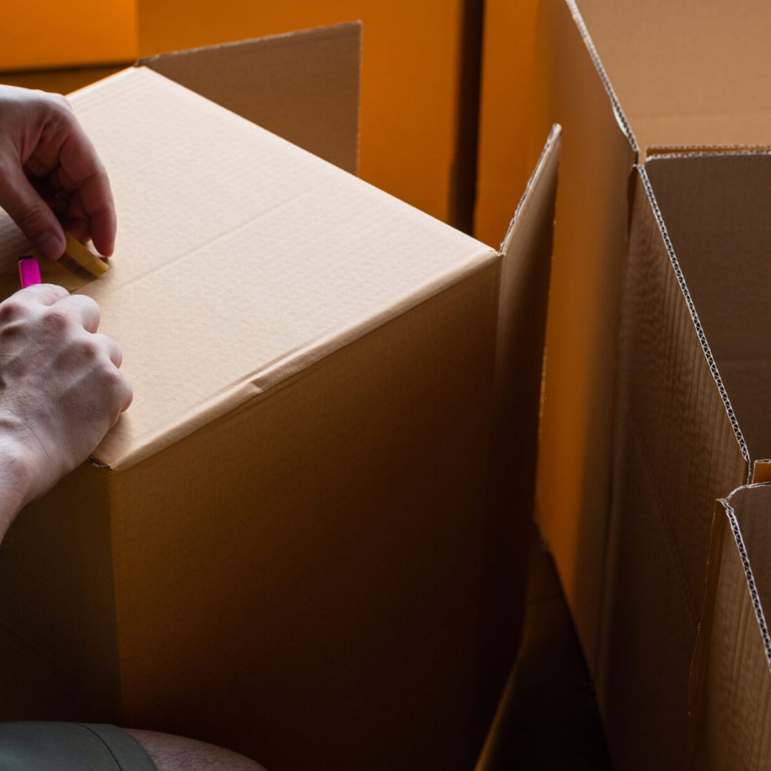 hand sealing parcel boxes at the warehouse distribution, Worker working and checking boxes before delivery