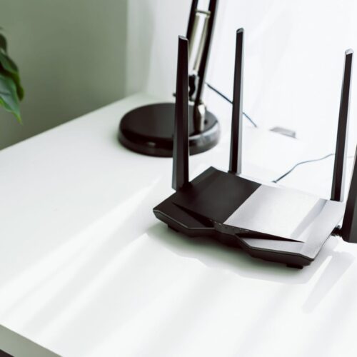 Wifi and broadband router on white table in room at the home.