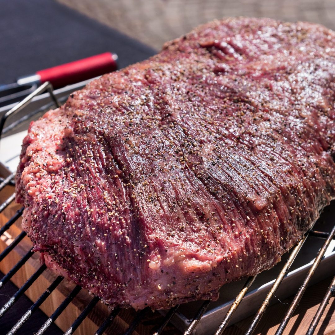 Portion of beef brisket seasoned with spices ready for grilling